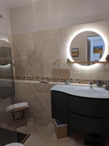W łazience znajduje się umywalka i lustro. w obiekcie French Riviera Condo 4 Rent in Marina Baie des Anges w mieście Villeneuve-Loubet