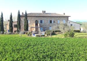 a large stone house in the middle of a field at Borgo Solario in Castiglione del Lago