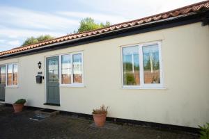 a white house with a green door and windows at PERFECT BUSINESS ACCOMMODATION at SIDINGS FARM - Luxury Cottage Accommodation - Self Catering - Secure Parking - Fully equipped Kitchen - Towels & Linen included in Pidley