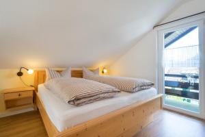 a bedroom with a bed and a large window at Ferienwohnungen Alpentraum - Gerstruben in Fischen