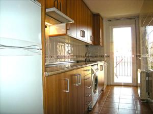 a kitchen with a refrigerator and a stove top oven at Apartamentos El Hortalán in Mora de Rubielos