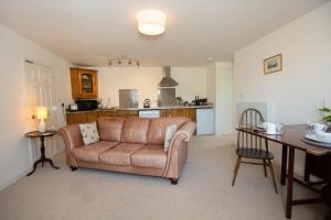 a living room with a couch and a table at PERFECT BUSINESS ACCOMMODATION at SIDINGS FARM - Luxury Cottage Accommodation - Fully equipped & Self Catering in Pidley
