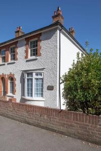 a white brick house with a brick wall at Seacroft in Kingsdown