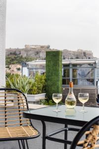 アテネにあるAmazing Penthouses with Acropolis Viewのバルコニーにテーブルとワイン2杯