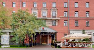 un gran edificio de ladrillo rojo con puerta en Maxima Zarya Hotel, en Moscú