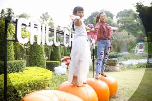 two young girls standing on pumpkins in a garden at Chill chill farm resort in Phetchabun