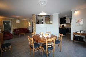 een keuken en een woonkamer met een houten tafel en stoelen bij Belle maison in Argonay