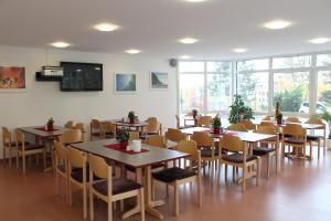 a dining room with tables and chairs and windows at Sportpension Dresden in Dresden +17 photos