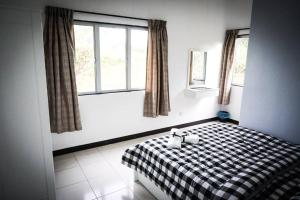a bedroom with a black and white checkered bed at 80'S PARADISE in Tanah Rata