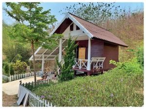 a small house with a porch and a fence at Chill chill farm resort in Phetchabun
