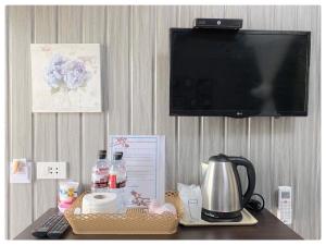 a table with a coffee maker and a tv on a wall at Chill chill farm resort in Phetchabun