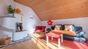 ein Wohnzimmer mit einem Sofa und einem Stuhl in der Unterkunft Ferienhaus Felicitas in Strobl