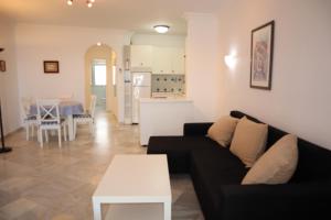 uma sala de estar com um sofá preto e uma mesa branca em Stella Maris 1B Casasol Apartments em Nerja