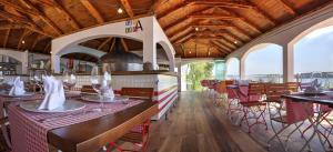 un ristorante con soffitti e tavoli in legno e sedie di Happy Camp mobile homes in Camping Amadria Park Camping Trogir a Seget Vranjica