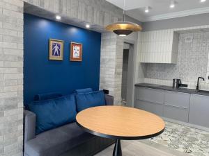 リヴィウにあるKraft Boutique Apart-Hotelのリビングルーム(青いソファ、テーブル付)