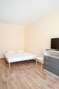 a white room with a bed and a tv at Квартира Аэропорт Красноярск in Yemel'yanovo