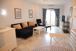 uma sala de estar com um sofá preto e uma mesa em Stella Maris 1B Casasol Apartments em Nerja