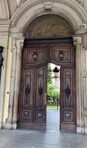 トリノにあるRe Vittorioの大きな木製のドアのある建物の入口