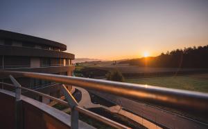 una vista sul tramonto da un balcone di un edificio di Pflegehotel Sutz-Lattrigen a Sutz-Lattrigen