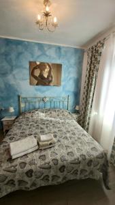 um quarto com uma cama com uma parede azul em Appartamento Shabby em Bosa