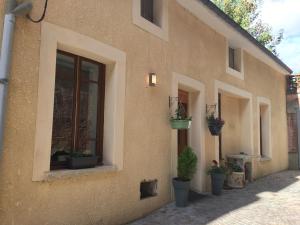 a building with potted plants on the side of it at La Halte Effervescente in Épernay