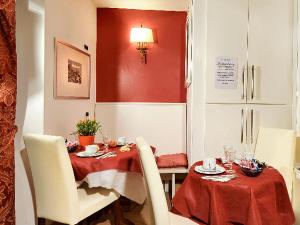 ein Esszimmer mit einem Tisch und einem roten Tischtuch in der Unterkunft Locanda Casa Querini in Venedig