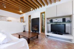 a living room with a couch and a tv and a table at Villa Son Floriana in Son Servera