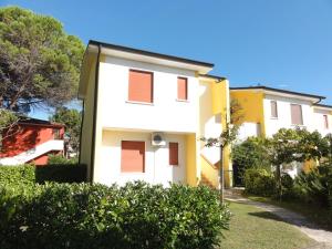 un edificio blanco con persianas naranjas. en Villaggio Azzurro, en Bibione