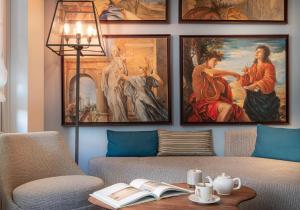 a living room with four paintings on the wall at Hôtel Le Walt by Inwood Hotels in Paris