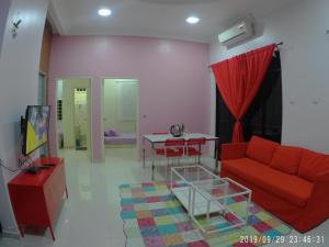 a living room with a red couch and a table at Holiday Homestay Dungun in Dungun