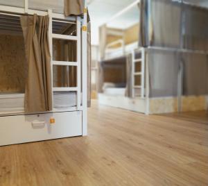 an empty room with two bunk beds and a wooden floor at Albergue Nacama hostel Pontevedra in Pontevedra