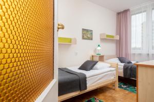 - une chambre avec 2 lits et un mur jaune dans l'établissement Apartments Warsaw Arabska, à Varsovie