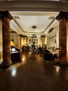 ブカレストにあるグランド ブティック ホテルの柱、テーブル、椅子が備わる広い客室です。