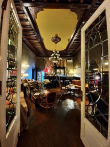 a living room with tables and chairs and a chandelier at Grand Boutique Hotel in Bucharest