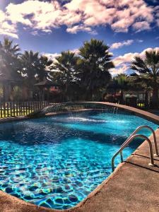 una gran piscina con agua azul y palmeras en Apart Hotel Gran Pacifico, en La Serena