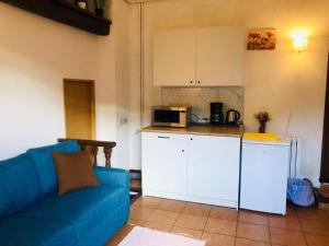 a living room with a blue couch and a kitchen at Casa les Pomeretes in El Figaró