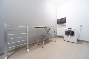 a laundry room with a washing machine and a table at Vesna Hotel in Nizhny Novgorod