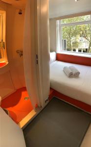 two beds in a small room with a window at easyHotel South Kensington in London
