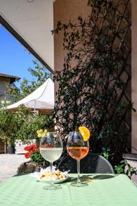 dos copas de vino sentadas en una mesa en Hotel Dolomiti, en Vattaro
