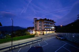 ein Gebäude mit einem Auto auf einem Parkplatz in der Unterkunft Hotel Dolomiti in Vattaro