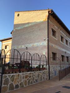 a large brick building with gates in front of it at Apartamentos "Casa Rural de Aldea" in Aldea del Fresno