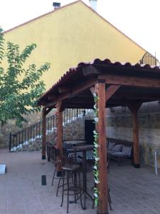 Apartamentos "Casa Rural de Aldea" في Aldea del Fresno: بريقولا خشبي مع الكراسي والطاولات على الفناء