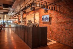 a brick wall with a bar in a restaurant at Qama Hotel in Prishtinë