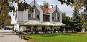 戈乌达普Parkova - pokoje hotelowe的一座带桌椅的大型白色房子