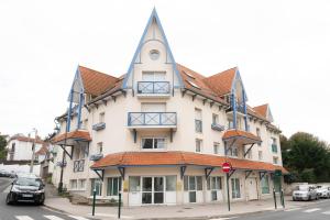 een groot wit gebouw met een torentje op een straat bij le ciel d'opale in Wimereux