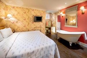 Schlafzimmer mit einem Bett, einer Badewanne und einem Waschbecken in der Unterkunft Fielding Hotel in London