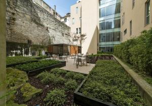 a garden area with a patio and a large building at Moov Hotel Porto Centro in Porto