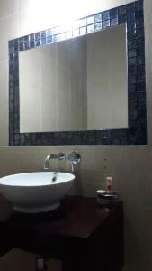 a bathroom with a sink and a large mirror at Hotel Arbol de Sueños in San Salvador