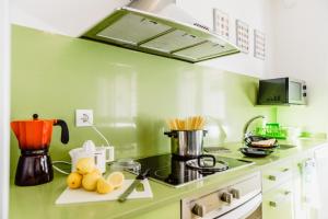トラダンバーラにあるHauzify I Loft Minetaの緑の壁のキッチン(コンロ付) 上部オーブン