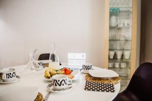 トラダンバーラにあるHauzify I Loft Minetaのテーブル(カップ、皿、食べ物付)